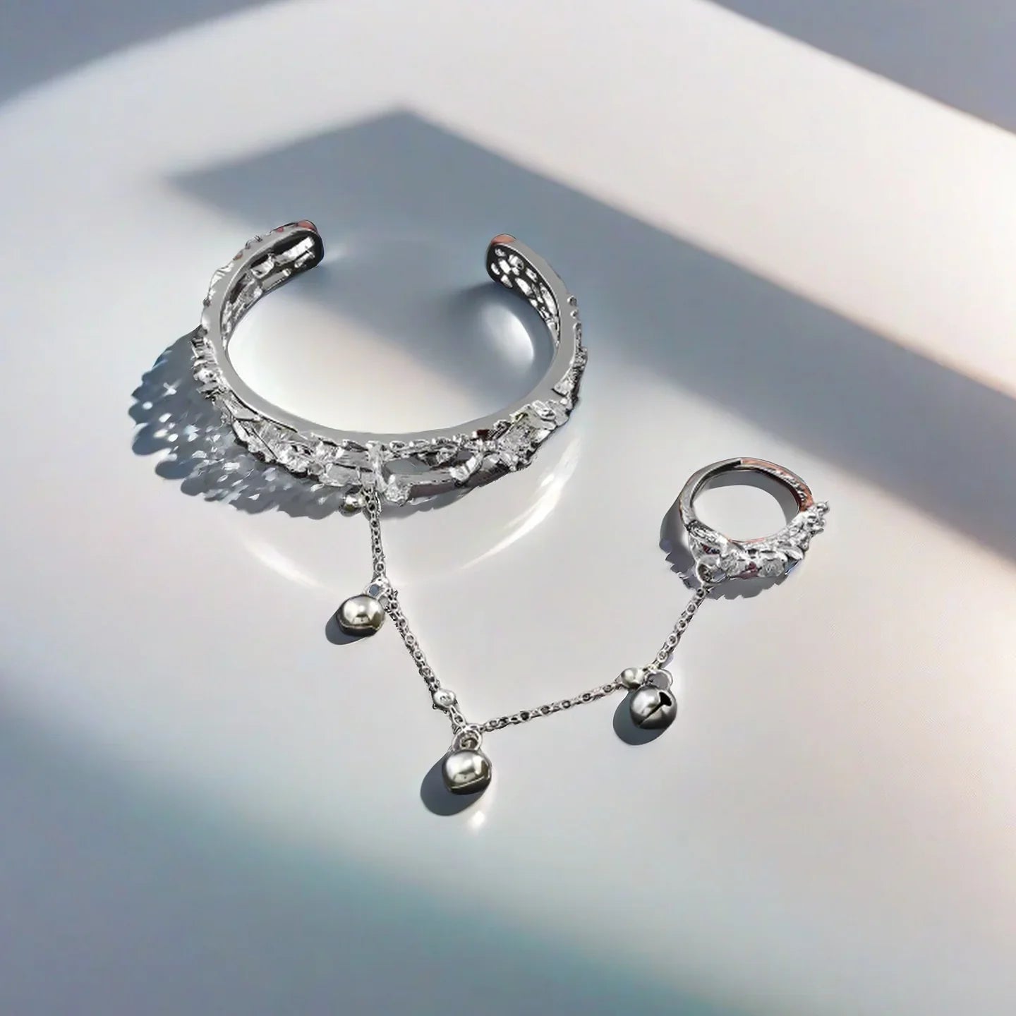 Detailed view of TGCF Hua Cheng & Xie Lian cosplay bracelet with silver bangle and matching ring, connected by a chain with bells for cosplay use.