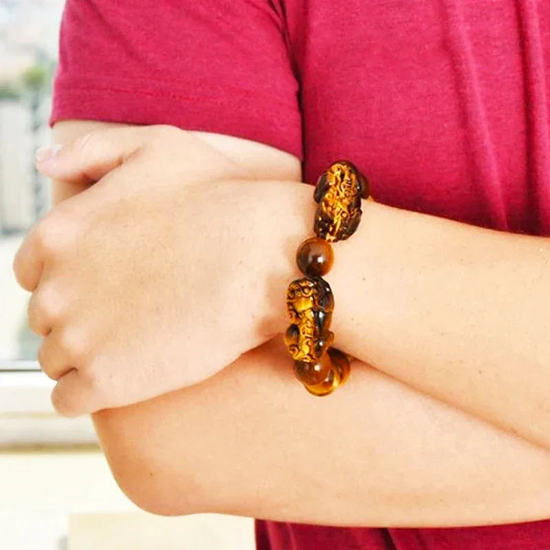Man wearing Tiger Eye Beads Feng Shui Bracelet featuring Pixiu charms, a stylish amulet for attracting wealth and protection.