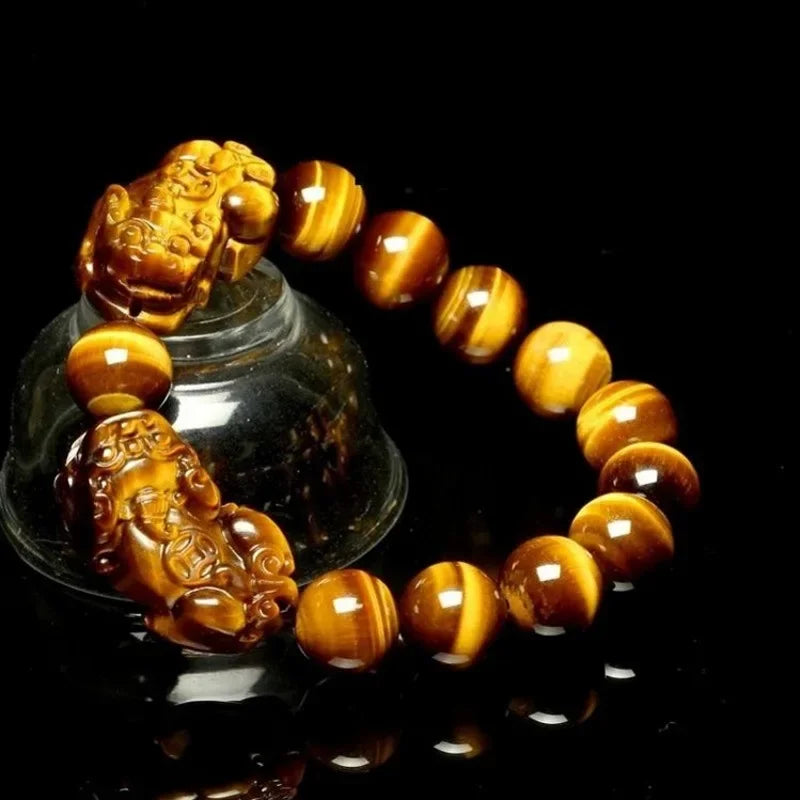 Tiger Eye Beads Feng Shui Bracelet with Pixiu wealth charms, displayed on a glass stand, perfect for men and women seeking good luck.