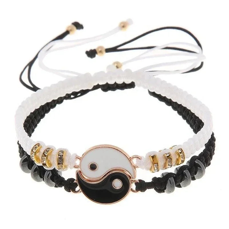 Dual-tone Yin Yang bracelet pair with gold-accented Tai Chi symbol, black and white cords, and decorative beads for couples.