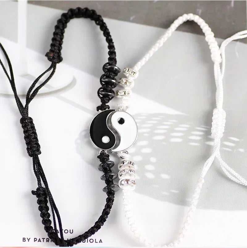 Stylish handmade Yin Yang bracelets for couples with black and white cords, Tai Chi charm, and metallic bead embellishments.