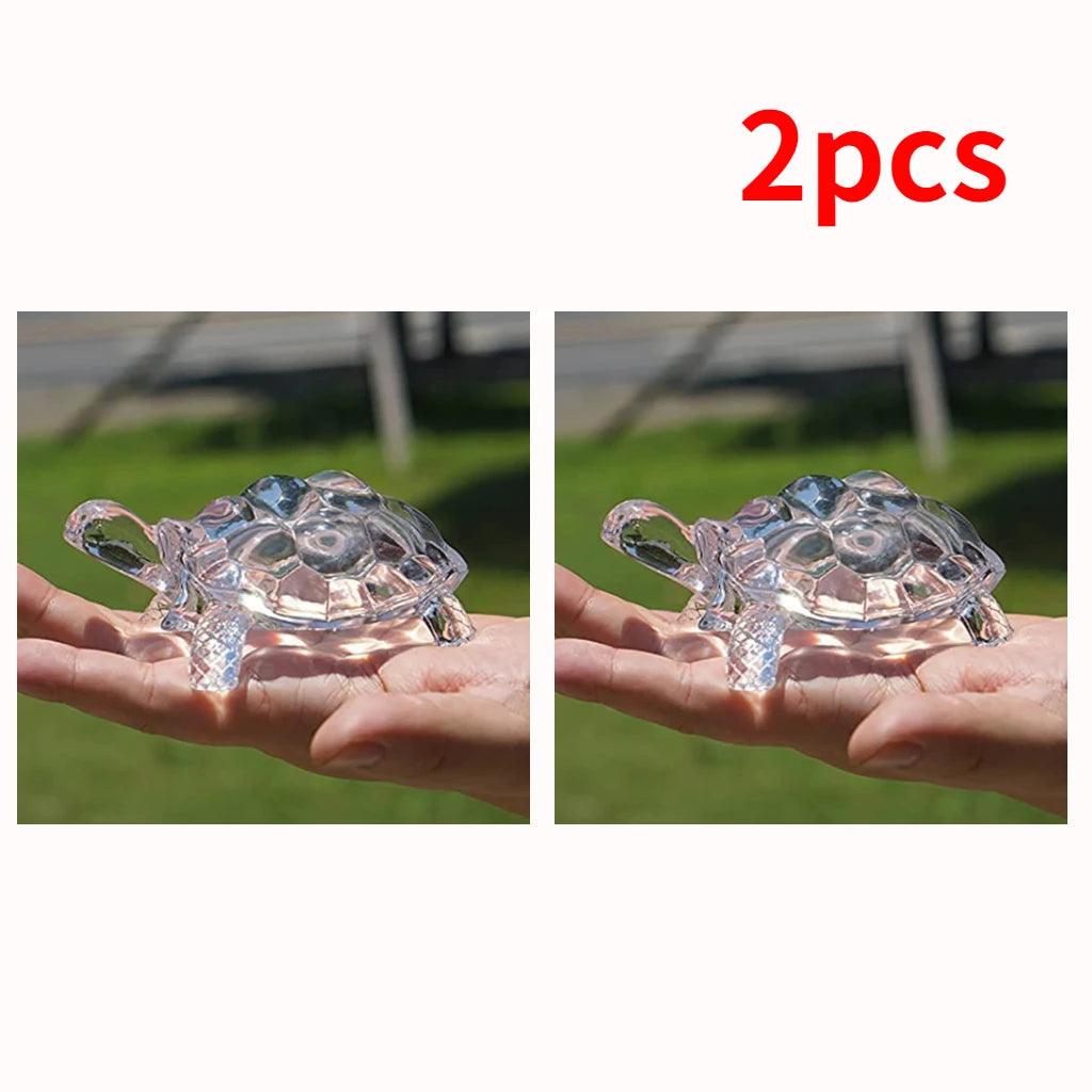 Set of 2 miniature crystal turtle figurines held in hand, feng shui lucky charm for home and office decoration.
