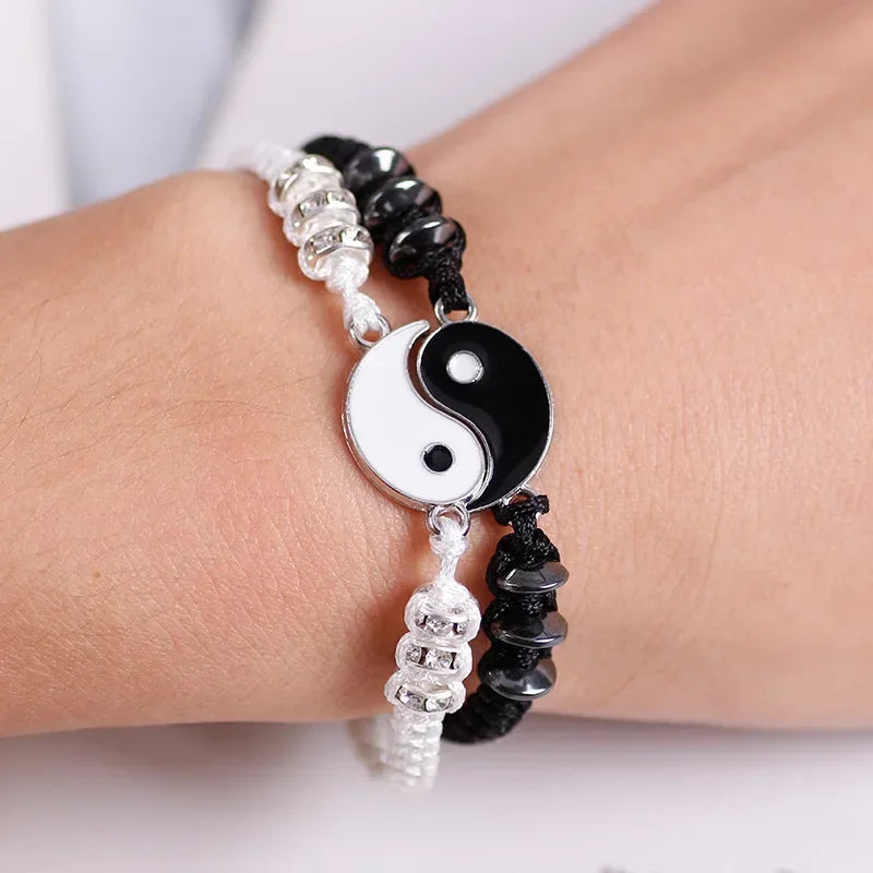 Close-up of Yin Yang couple bracelets on wrist, showcasing black and white Tai Chi charm with adjustable cord and decorative beads.