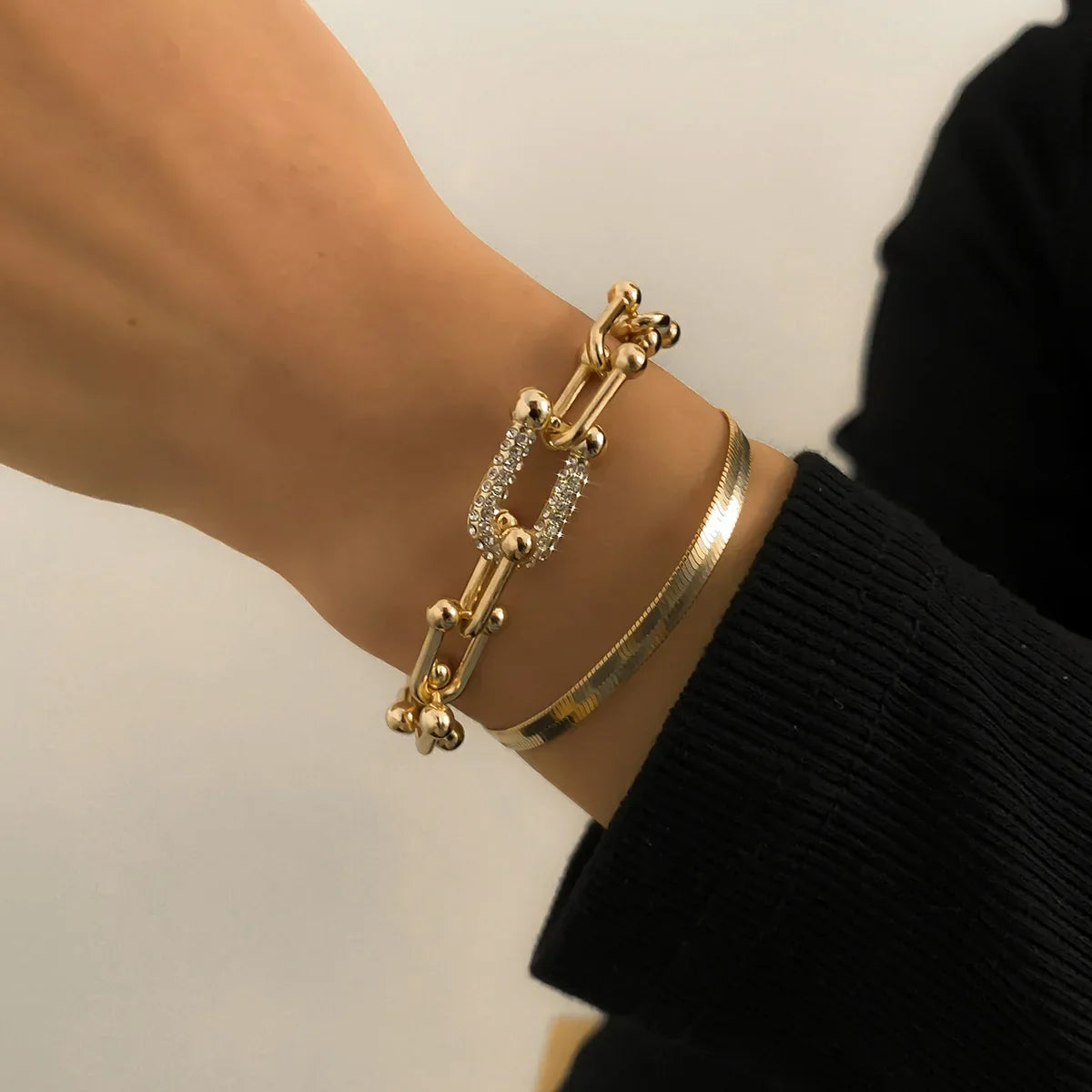 Gold U Chain and sleek bracelet from Trendy Geometric Bracelet Set worn on wrist, highlighting elegant layered accessory style.