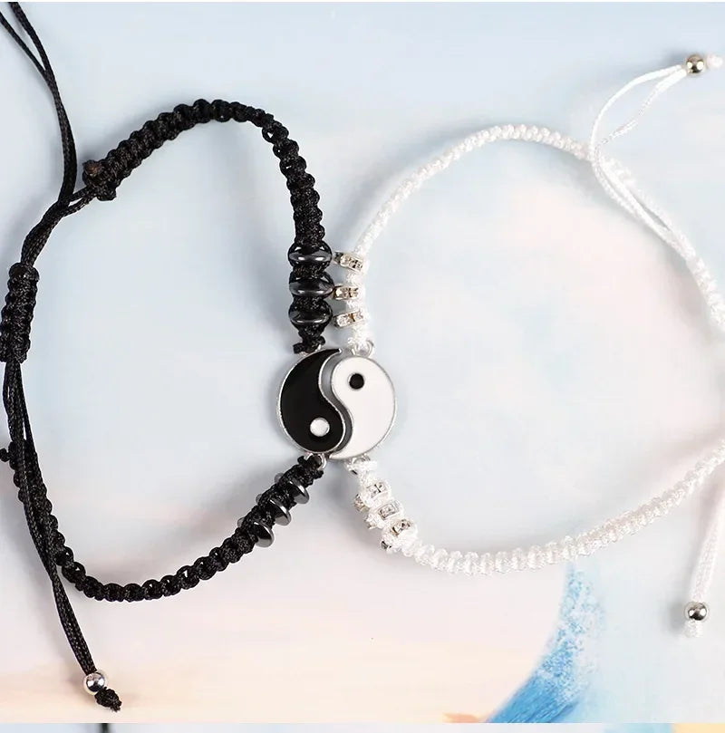 Matching black and white Yin Yang bracelets with Tai Chi symbol, adjustable cords, and bead details, perfect for couples.