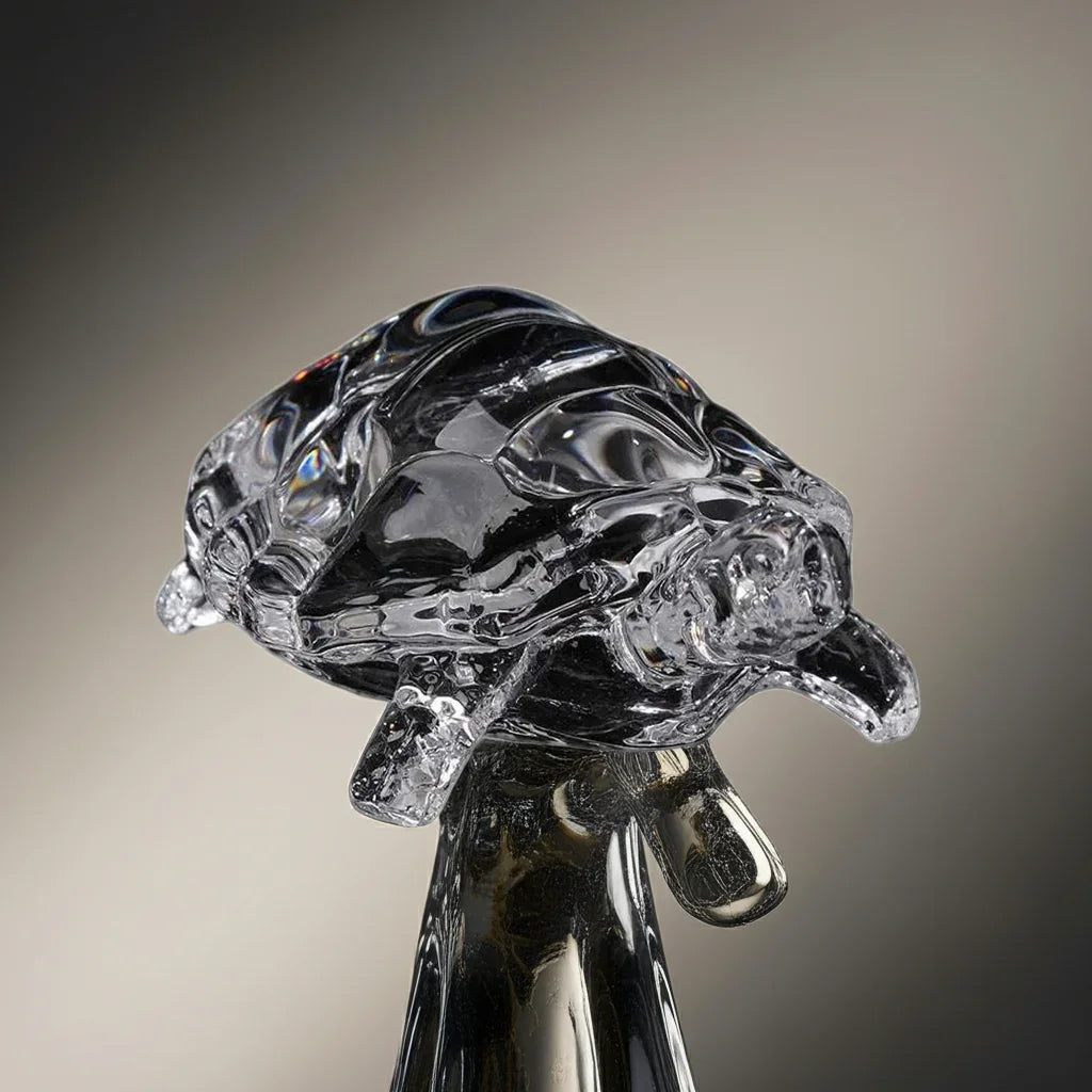 Miniature tortoise statue made of transparent crystal, displayed on a decorative stand for feng shui home decoration.
