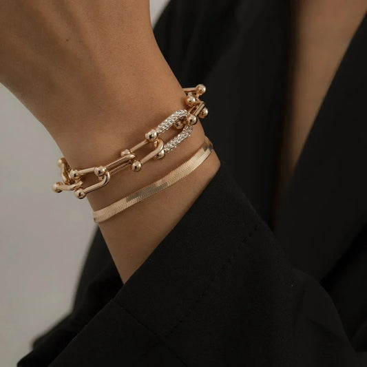 Trendy Geometric Bracelet Set – 2Pcs Gold U Chain styled on wrist with black blazer, showcasing chic layered fashion jewelry look.