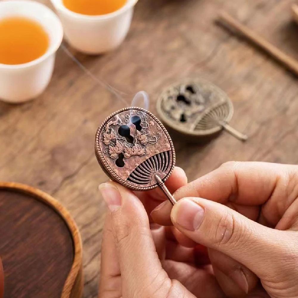 Fan-shaped incense coil holder with floral engravings, ideal for Feng Shui tea house decor and calming aromatherapy sessions.