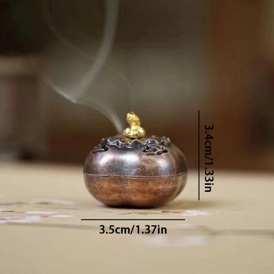 Round incense burner with golden lid accent and smoke release, measuring 3.5cm x 3.4cm, ideal for meditation and tea house decor.