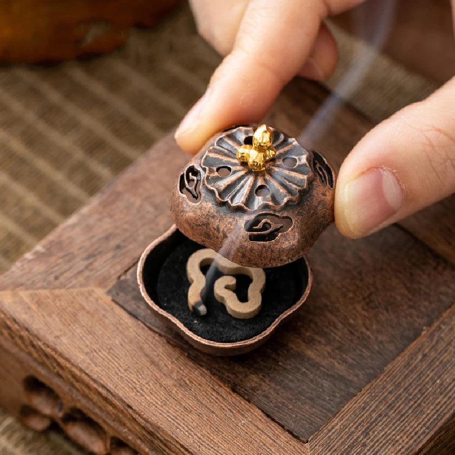 Vintage-style incense burner with floral lid and visible incense coil, designed for Zen aromatherapy and tea house ambiance.